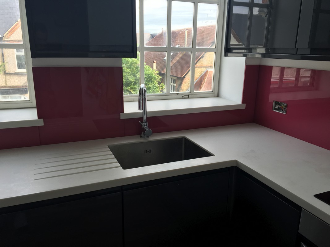 Deep plum coloured glass splashback in modern Southgate kitchen